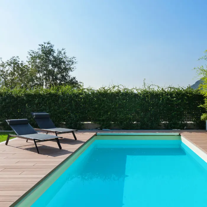 Piscine et plage en fond de jardin clos