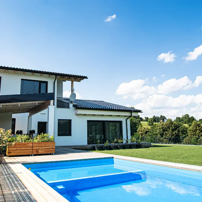 Villa contemporaine et son bassin, jardin fleuri en premier plan
